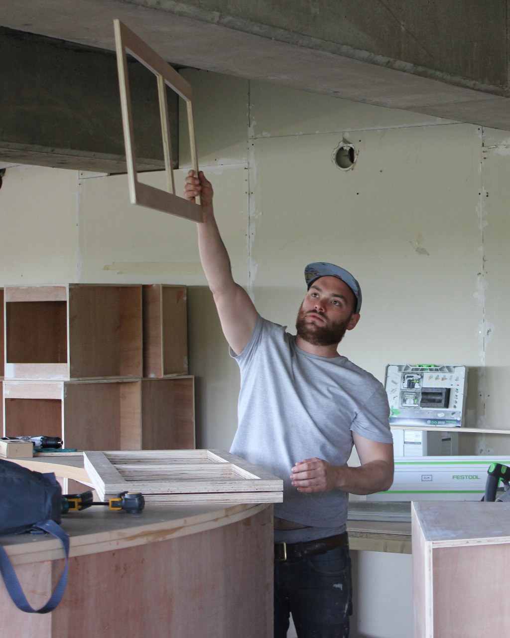 David Marsden holding up a made frame on site in Kent