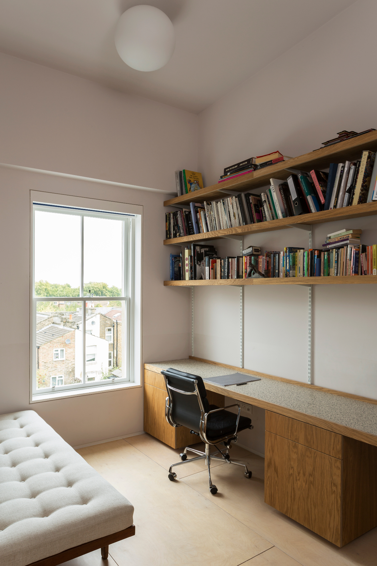 Fitted oak desk, drawers and bookshelves beside a sash window